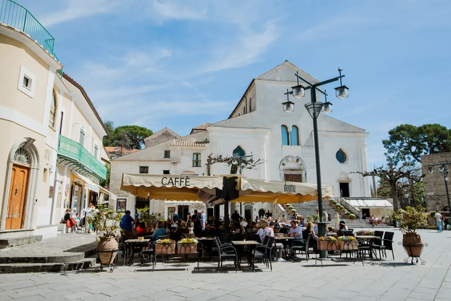 La piazza del Duomo con i tavolini del caffè sotto i tendoni