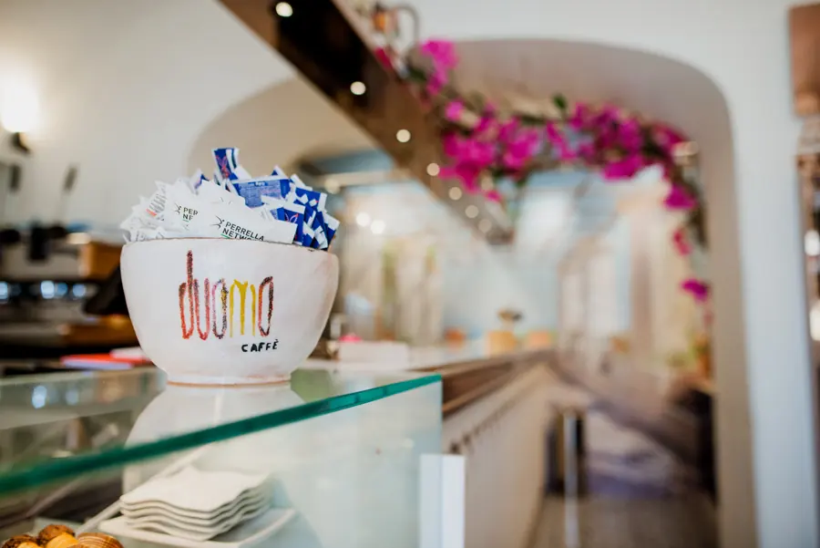 Una tazza con il logo del Duomo Caffè sul bancone